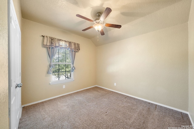 spare room with ceiling fan, lofted ceiling, carpet, and a textured ceiling