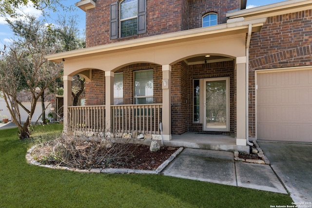 view of exterior entry with a porch, a garage, and a lawn