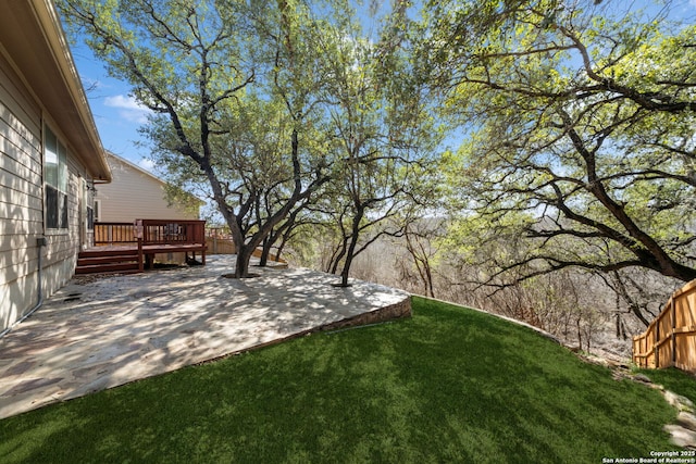 view of yard with a wooden deck and a patio area