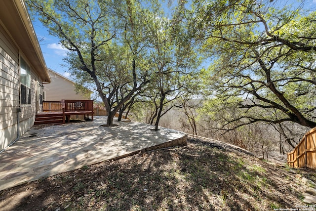 view of yard with a wooden deck and a patio