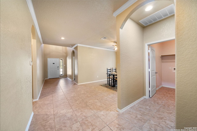 hall featuring ornamental molding, a textured ceiling, and light tile patterned flooring