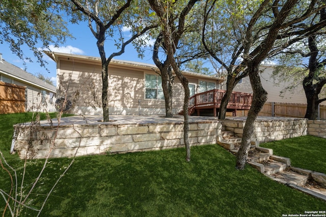 back of property with a wooden deck and a yard