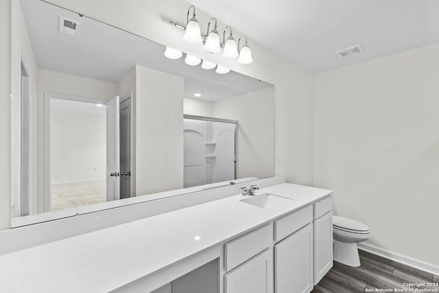 bathroom featuring an enclosed shower, hardwood / wood-style floors, vanity, and toilet