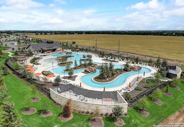 view of pool featuring a lawn and a rural view