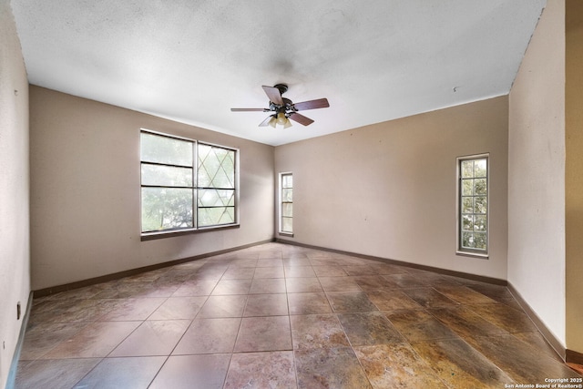 unfurnished room featuring ceiling fan and a textured ceiling