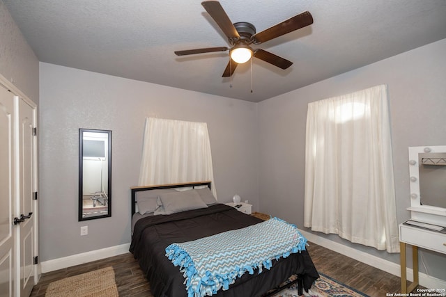 bedroom with ceiling fan, dark hardwood / wood-style floors, and a textured ceiling