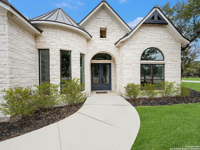 doorway to property with french doors and a lawn