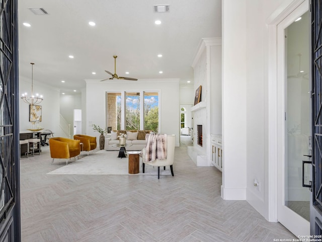 living room with crown molding, a fireplace, light parquet flooring, and ceiling fan with notable chandelier