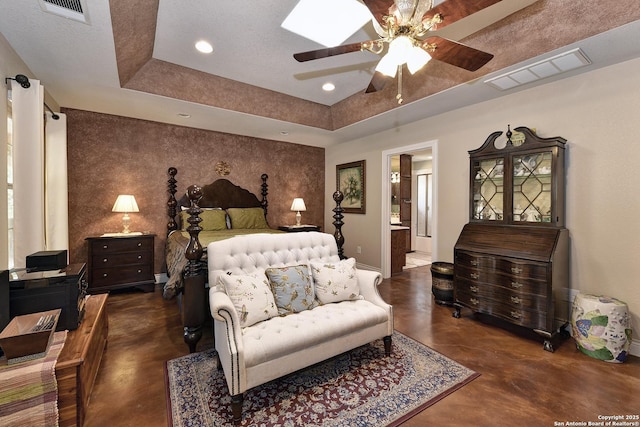bedroom featuring ensuite bathroom, ceiling fan, and a tray ceiling