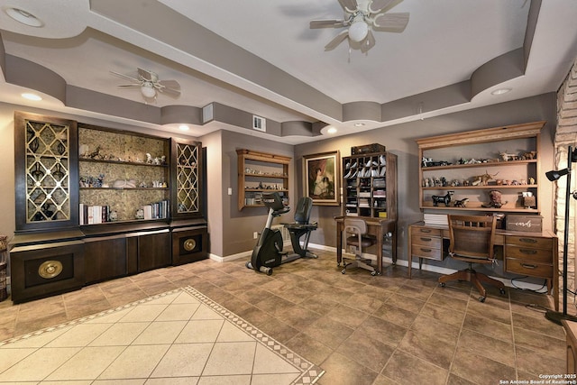 wine cellar featuring tile patterned flooring, a tray ceiling, ceiling fan, and indoor bar