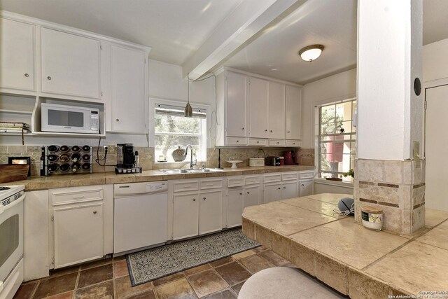 kitchen featuring sink, white appliances, a wealth of natural light, white cabinets, and decorative backsplash