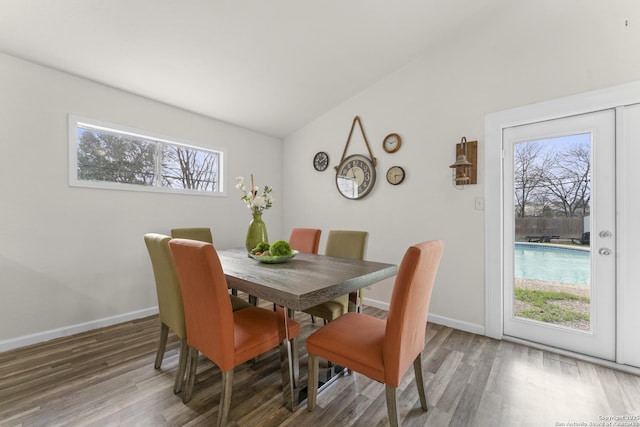 dining space with lofted ceiling, plenty of natural light, and wood-type flooring