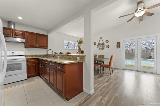 kitchen with sink, white range with electric stovetop, light stone countertops, kitchen peninsula, and french doors