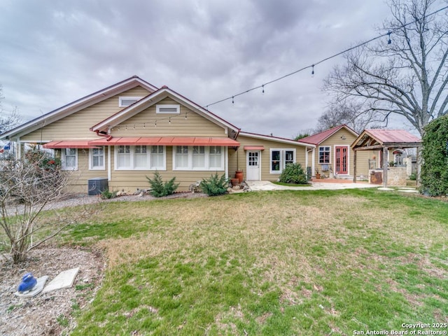 view of front of property with central AC unit and a front yard