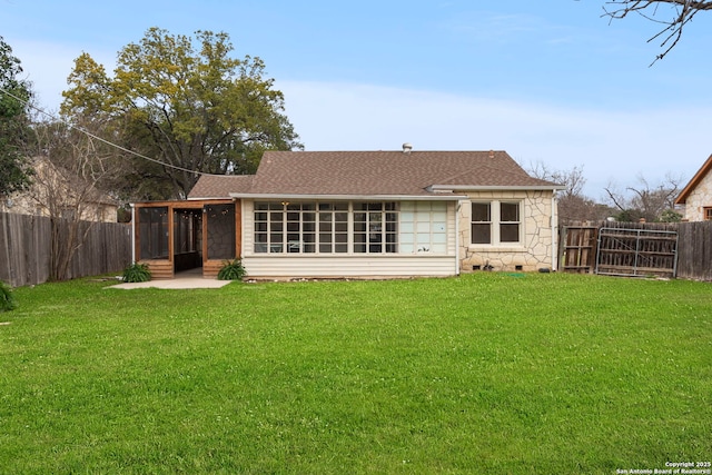 back of house featuring a sunroom and a yard