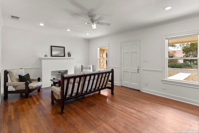 bedroom featuring dark hardwood / wood-style flooring, ornamental molding, and ceiling fan