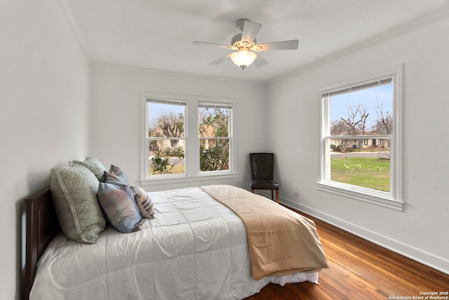 bedroom featuring hardwood / wood-style floors, crown molding, and ceiling fan