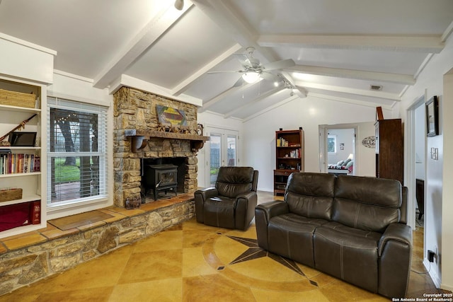 living room with vaulted ceiling with beams, ceiling fan, and a wood stove