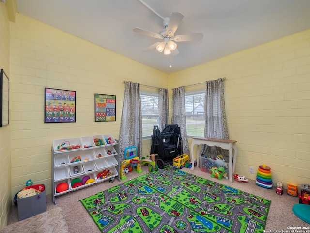 rec room featuring vaulted ceiling, brick wall, and ceiling fan