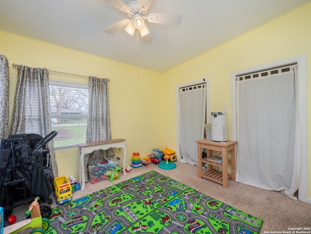 playroom featuring brick wall and ceiling fan