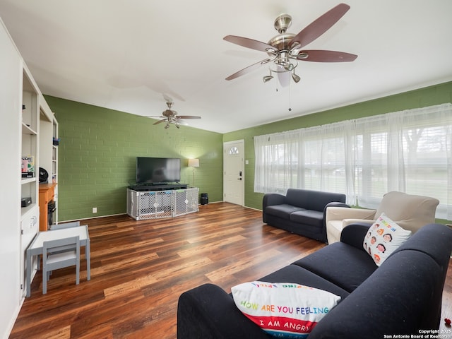 living room featuring dark hardwood / wood-style floors and brick wall