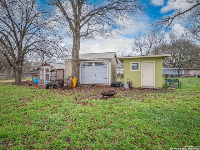 exterior space with a garage, an outbuilding, and a lawn