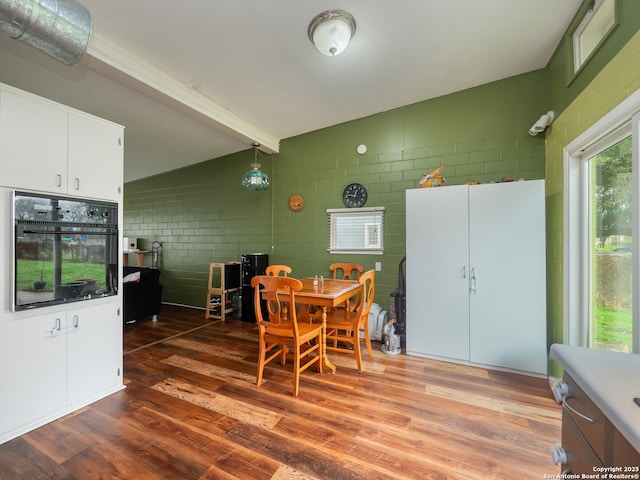 dining area featuring hardwood / wood-style flooring and beam ceiling