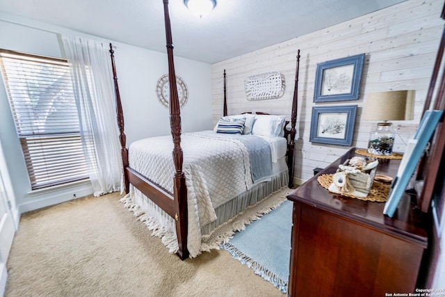 carpeted bedroom featuring wood walls