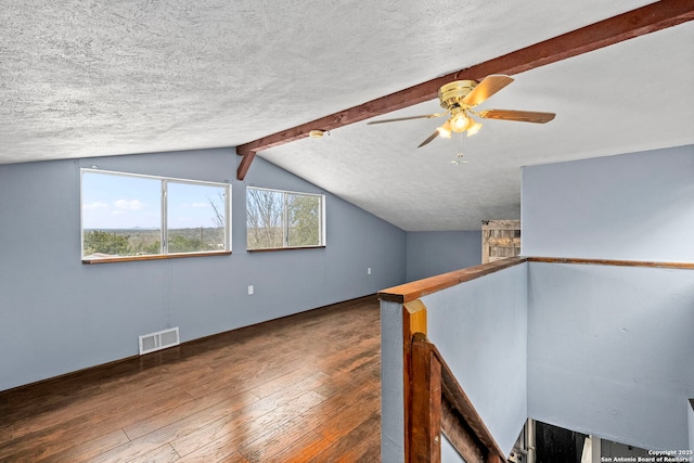 bonus room featuring wood-type flooring, vaulted ceiling with beams, ceiling fan, and a textured ceiling