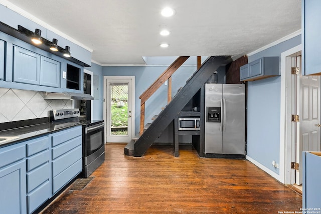 kitchen with dark hardwood / wood-style flooring, backsplash, ornamental molding, and appliances with stainless steel finishes