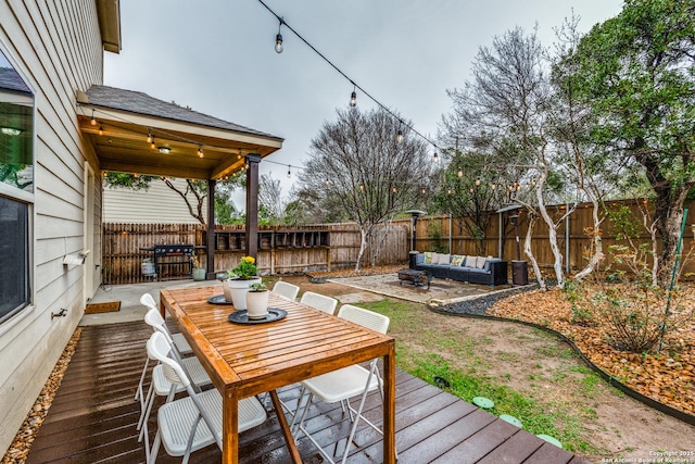 wooden deck with an outdoor hangout area and a patio area