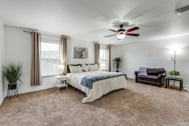 bedroom with multiple windows, carpet floors, and a textured ceiling