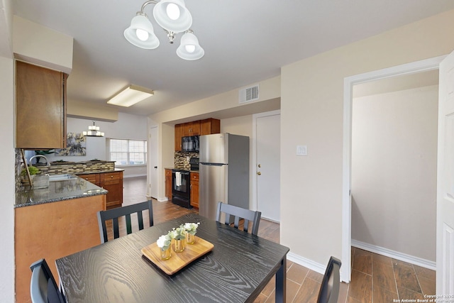 dining room with sink and a notable chandelier