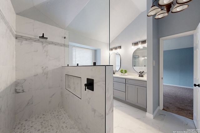 bathroom featuring lofted ceiling, vanity, and a tile shower