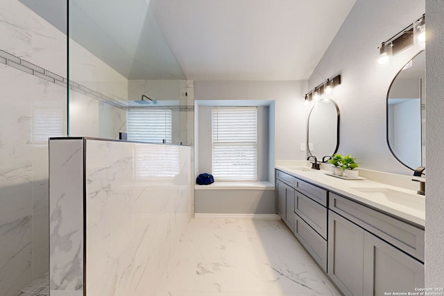 bathroom with tiled shower and vanity