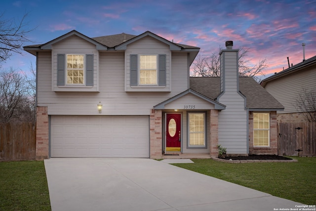 view of front of home with a garage and a lawn