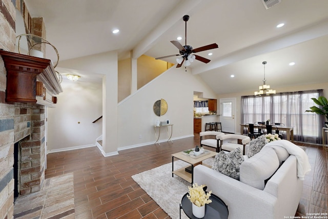 living room with ceiling fan with notable chandelier, a fireplace, high vaulted ceiling, and beamed ceiling