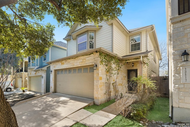 view of front facade featuring a garage, stone siding, fence, and concrete driveway