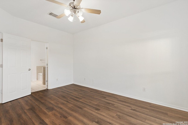 spare room with a ceiling fan, baseboards, visible vents, and wood finished floors