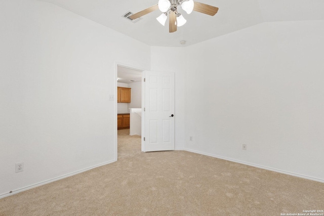 unfurnished room featuring light carpet, vaulted ceiling, visible vents, and baseboards