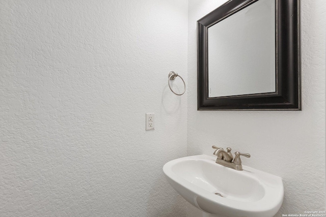 bathroom with a sink and a textured wall