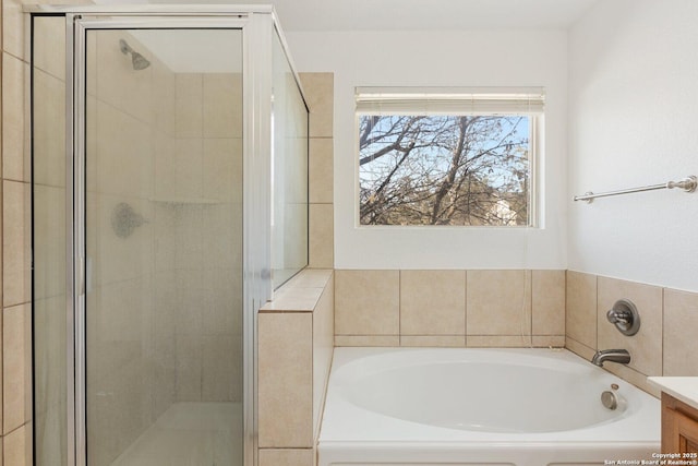 full bathroom featuring a garden tub, a shower stall, and vanity