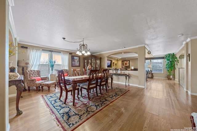 dining area featuring crown molding, light hardwood / wood-style flooring, and a healthy amount of sunlight