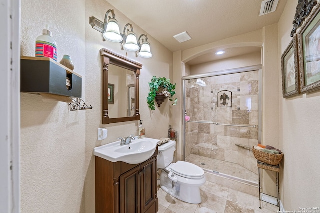 bathroom with vanity, a shower with shower door, and toilet