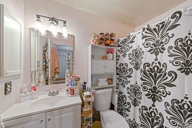 bathroom with vanity, curtained shower, a textured ceiling, and toilet