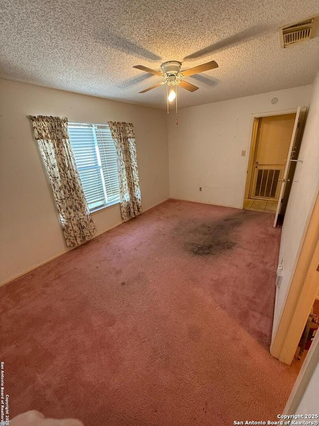 carpeted empty room featuring a textured ceiling and ceiling fan