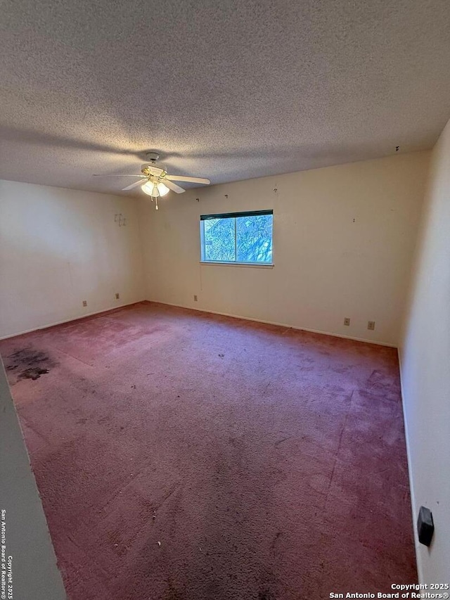 carpeted spare room featuring ceiling fan and a textured ceiling