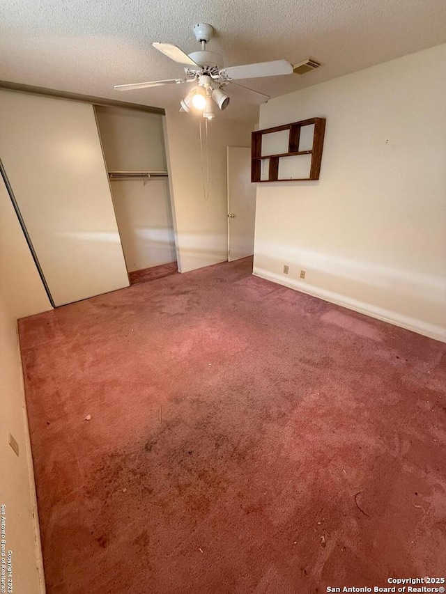 unfurnished bedroom featuring ceiling fan, carpet, a textured ceiling, and a closet