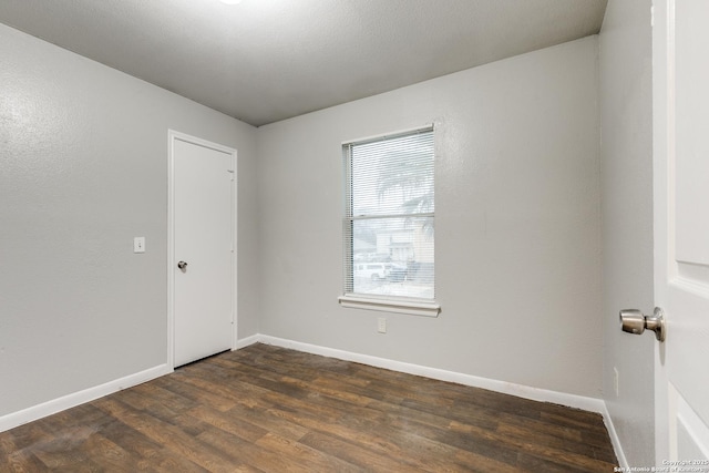 spare room with dark hardwood / wood-style flooring