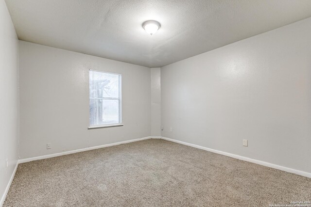 empty room featuring carpet floors and a textured ceiling